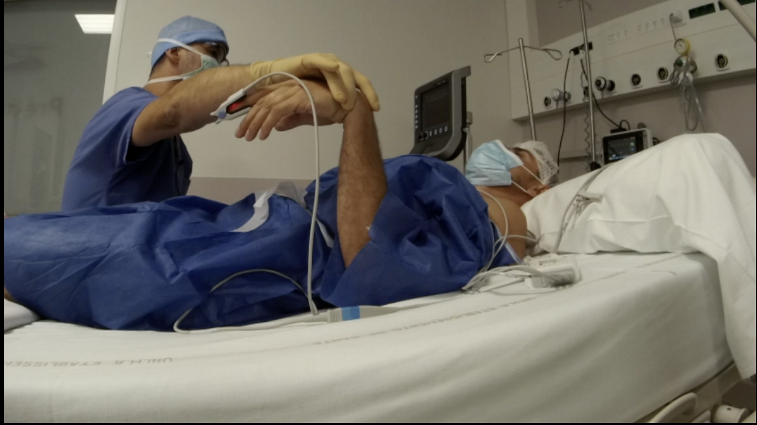 un médecin anesthésiste tiens la main d'un patient homme qui est allongé sur un lit en attente de son opération